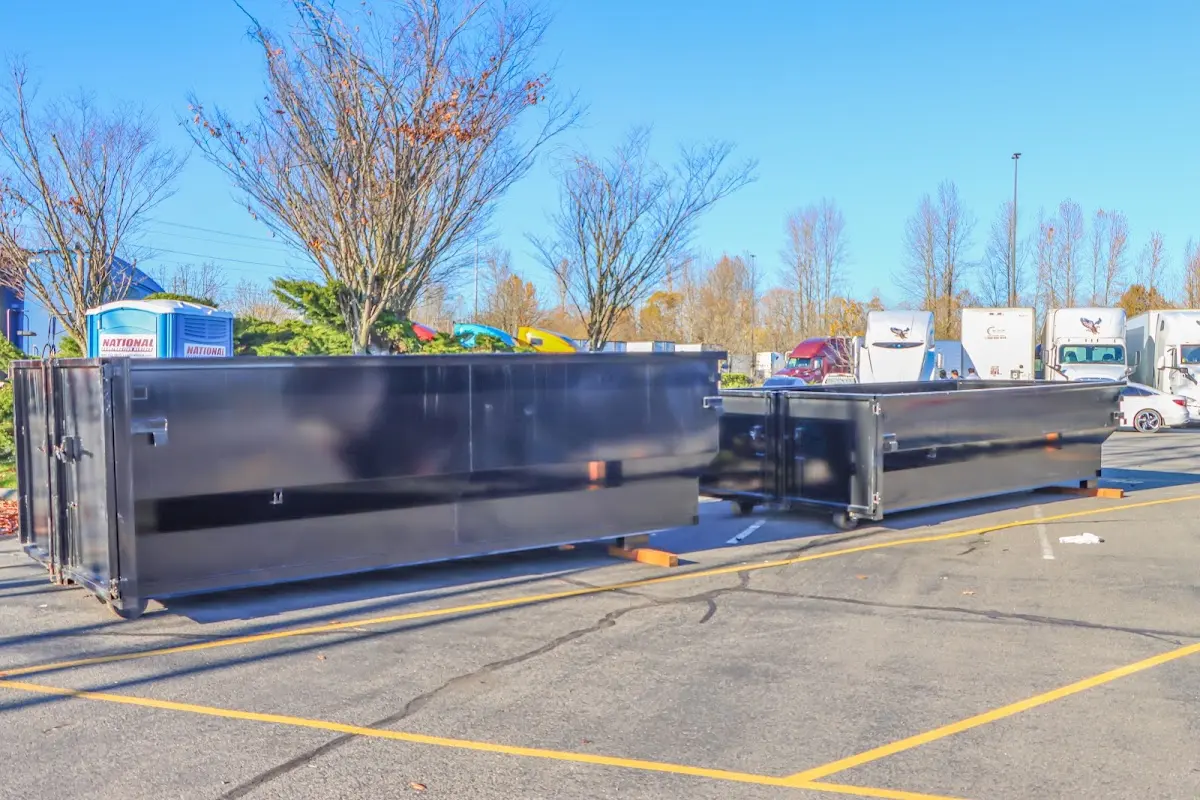 Professional dumpster rental service with roll-off container on residential driveway in Millis